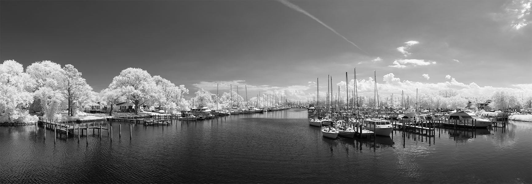 Infrared Panoramic Photograph of a River with Crowded Docks and Marinas on Each Side.